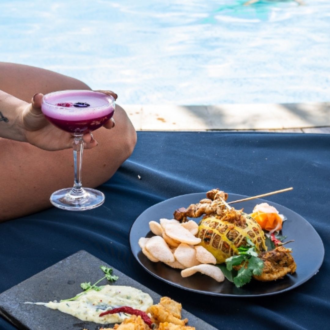 Cocktail and Mie Goreng on Beach Club bed with pool in background