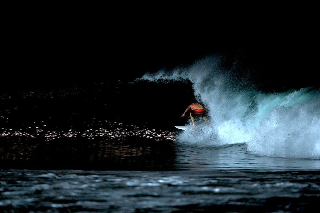 Hotel Komune founder Tony Cannon surfing at night under stadium floodlights at Keramas, the world's first permanent night surfing venue