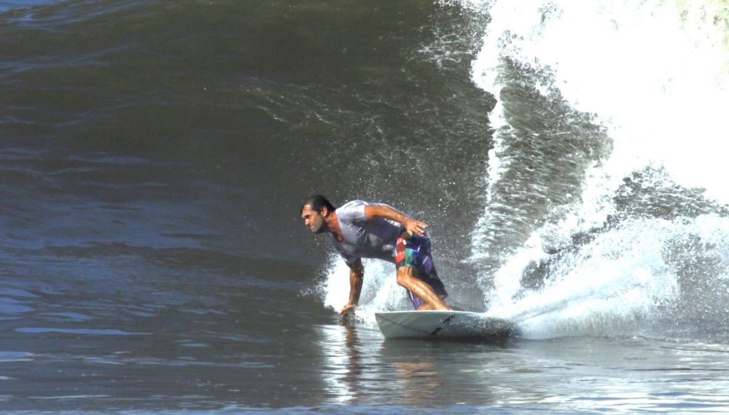Hotel Komune founder Tony Cannon bottom-turning on a small, playful wave at Keramas beach, Bali